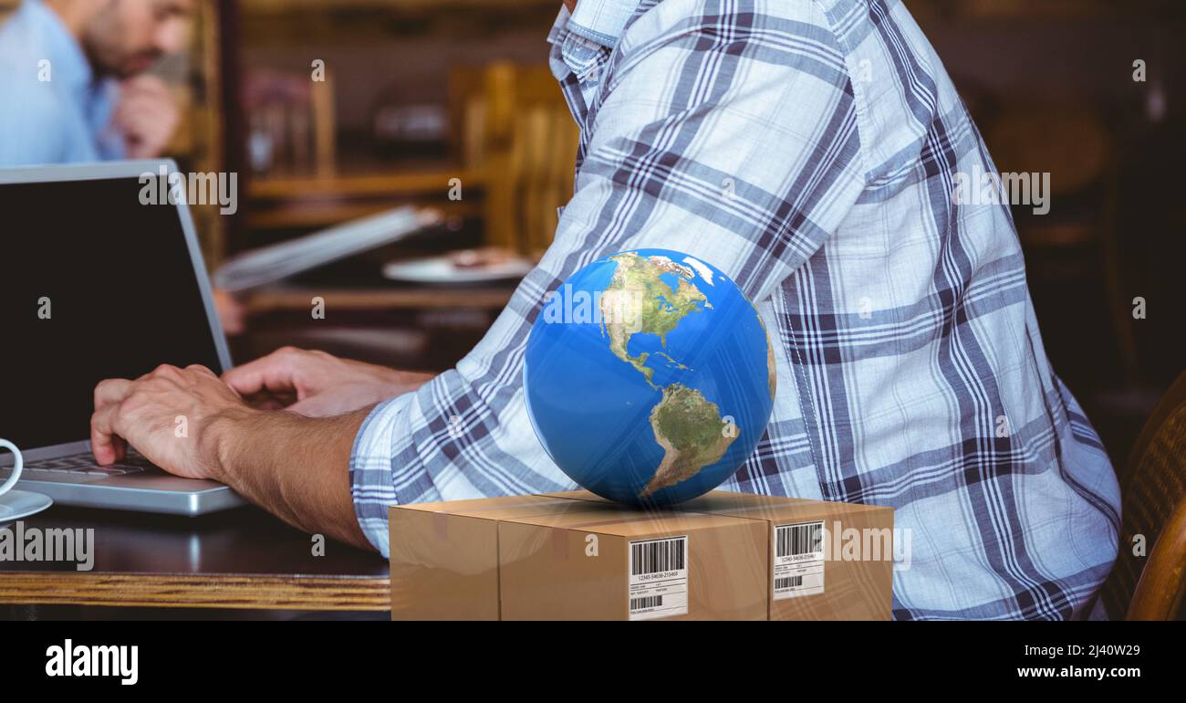 Globe over Delivery box against against Mid section of a Person using Laptop in a Cafe Stockfoto
