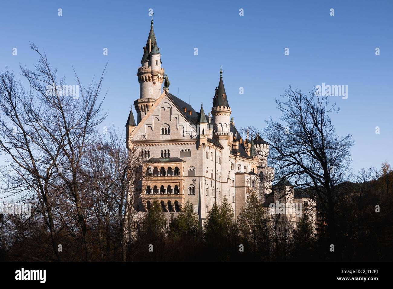 Hohenschwangau, Deutschland - 4. November 2019: Schloss Neuschwanstein, klassisches und altes Gebäude im Waldgebiet, das Sonnenlicht mit dem Hintergrund von cle berührt Stockfoto