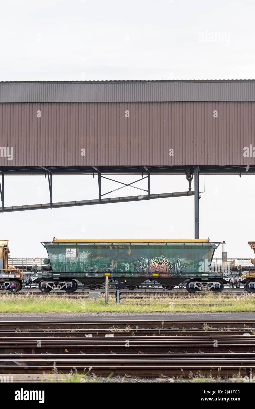 Verrostete Bahngleise und ein mit Graffiti bedeckter Triebwagen, der neben dem Port Waratah Coal Terminal in Carrington, Newcastle, New South Wales, Australien, gelagert wurde Stockfoto
