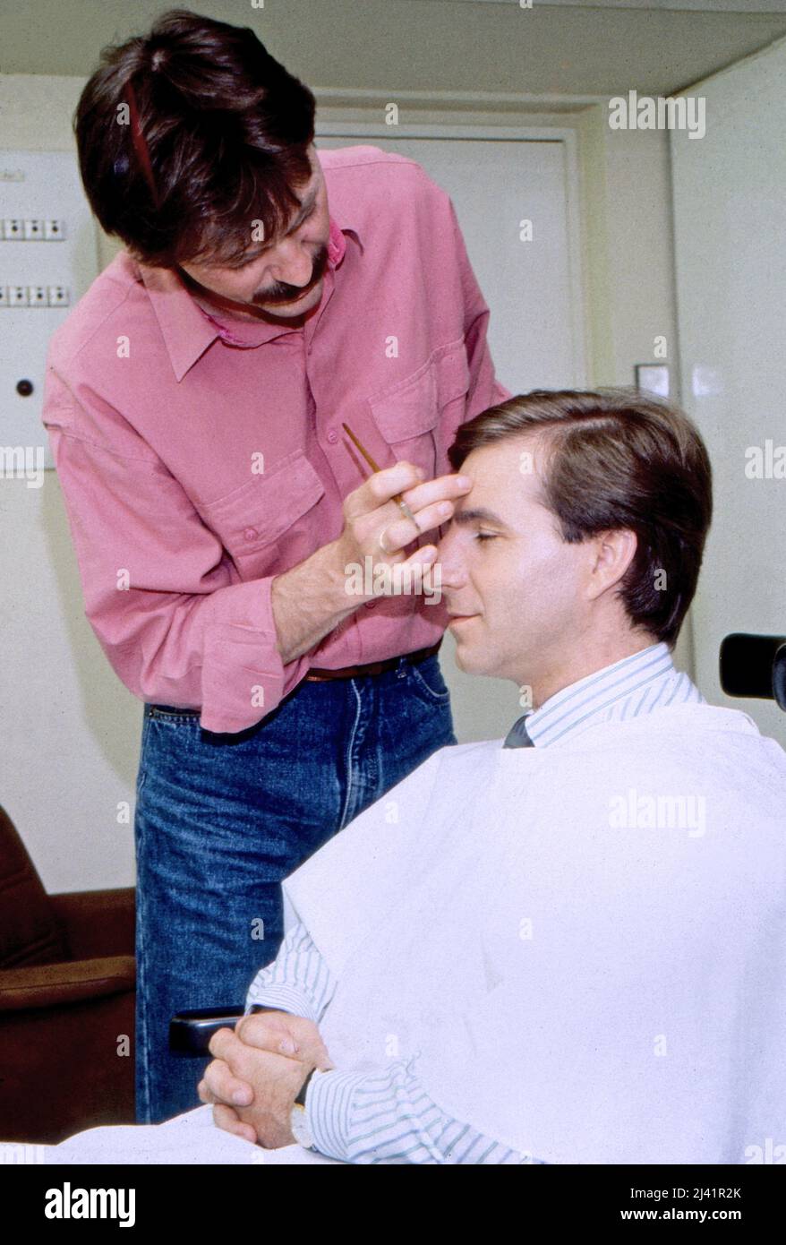 Jan Hofer, deutscher Nachrichtensprecher und Moderator, wird in der Maske geschminkt im Studio der Tagesschau, Deutschland um 1988. Stockfoto