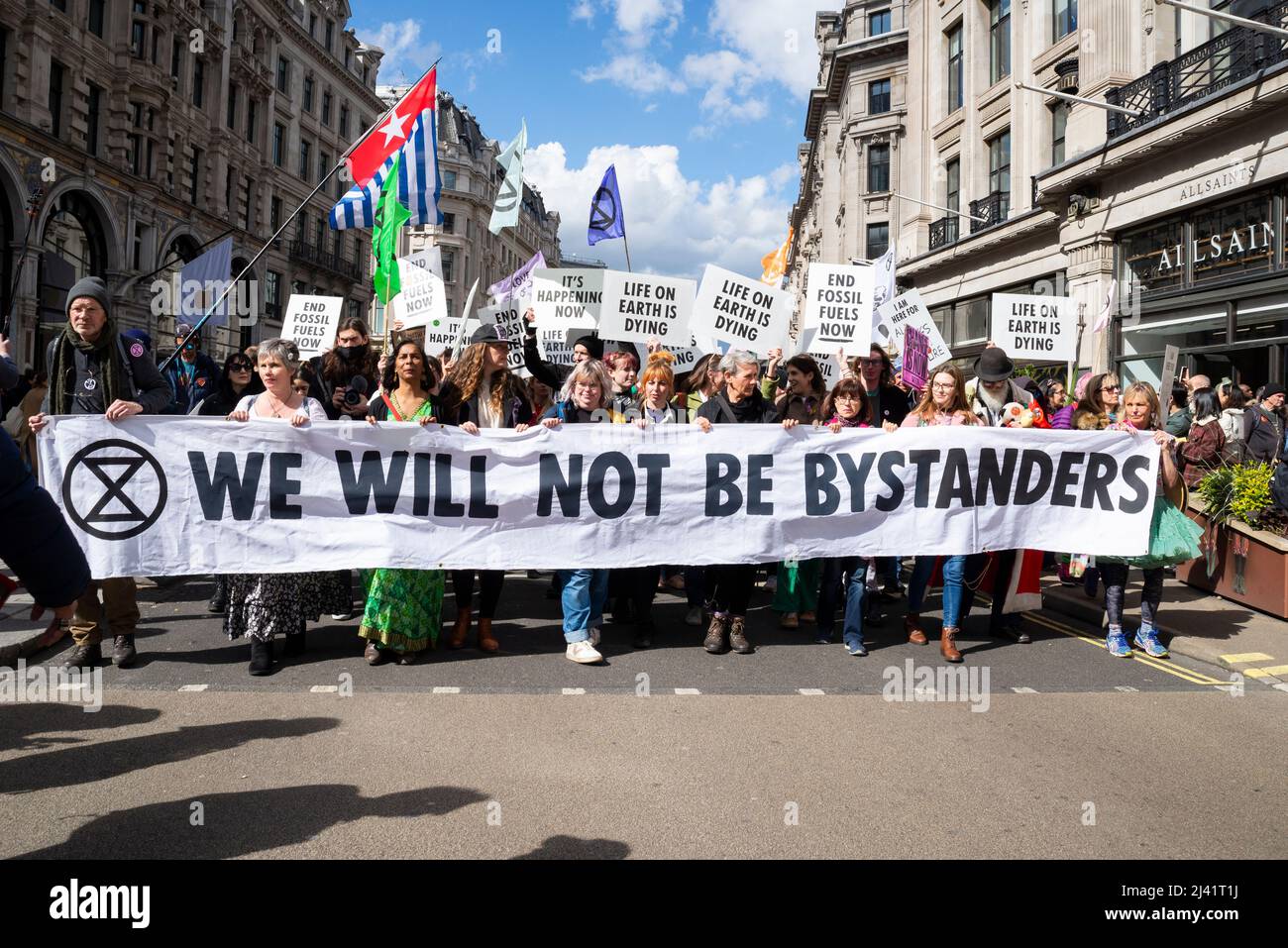 Extinction Rebellion Protestierende startenden in London ab dem 9. April 2022 eine Phase ziviler Störungen. Marschieren Sie die Regent Street mit einem Transparent entlang Stockfoto