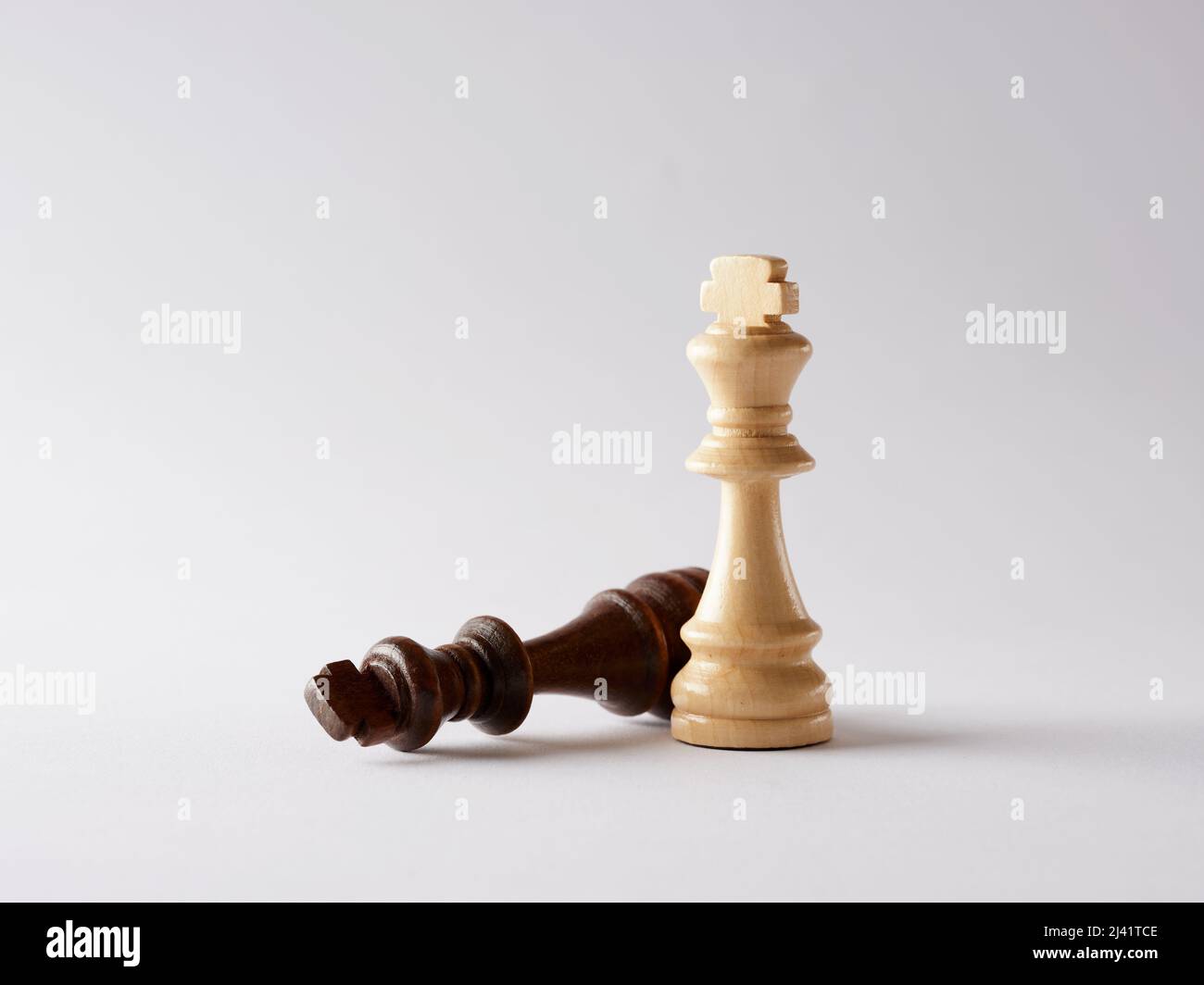 Weißer Schachkönig, der über dem gefallenen schwarzen König steht. Strategische Bewegung, Erfolg und Sieg oder die Rivalen im Geschäftskonzept zu besiegen Stockfoto
