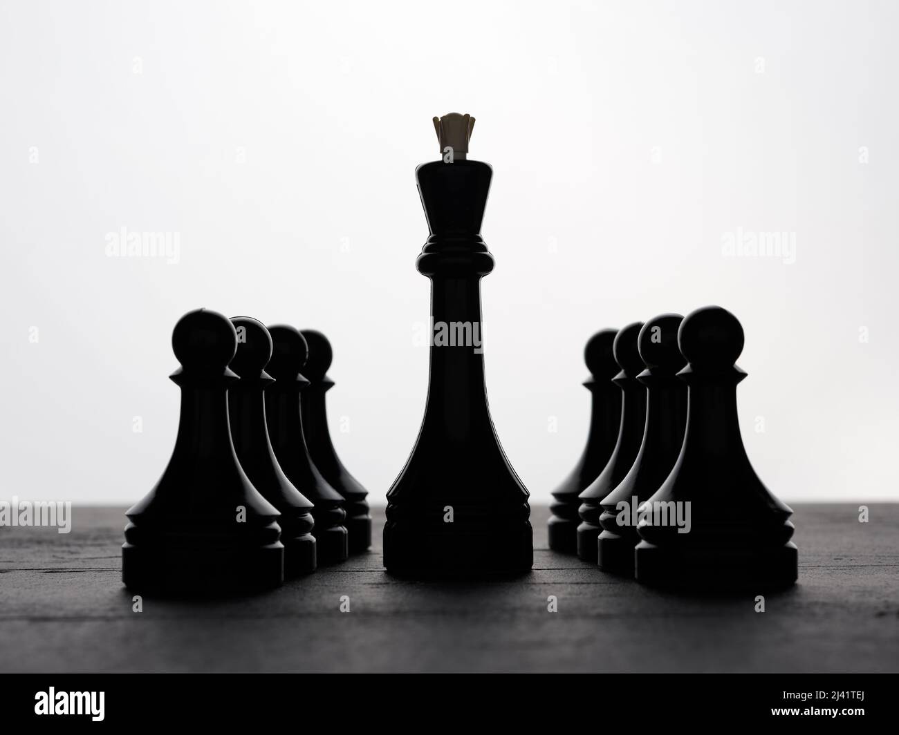 Schwarzer Schachkönig, der durch die Bauern läuft, reiht sich in einer Reihe an. Konzepte für strategische Führung, Macht, Autorität oder Führungskräfte. Stockfoto