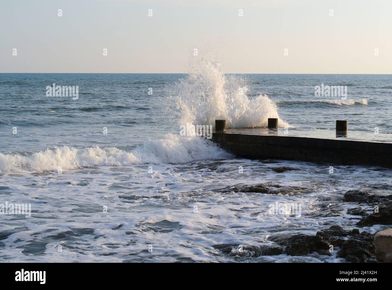 Wellen brechen auf dem Dock Stockfoto