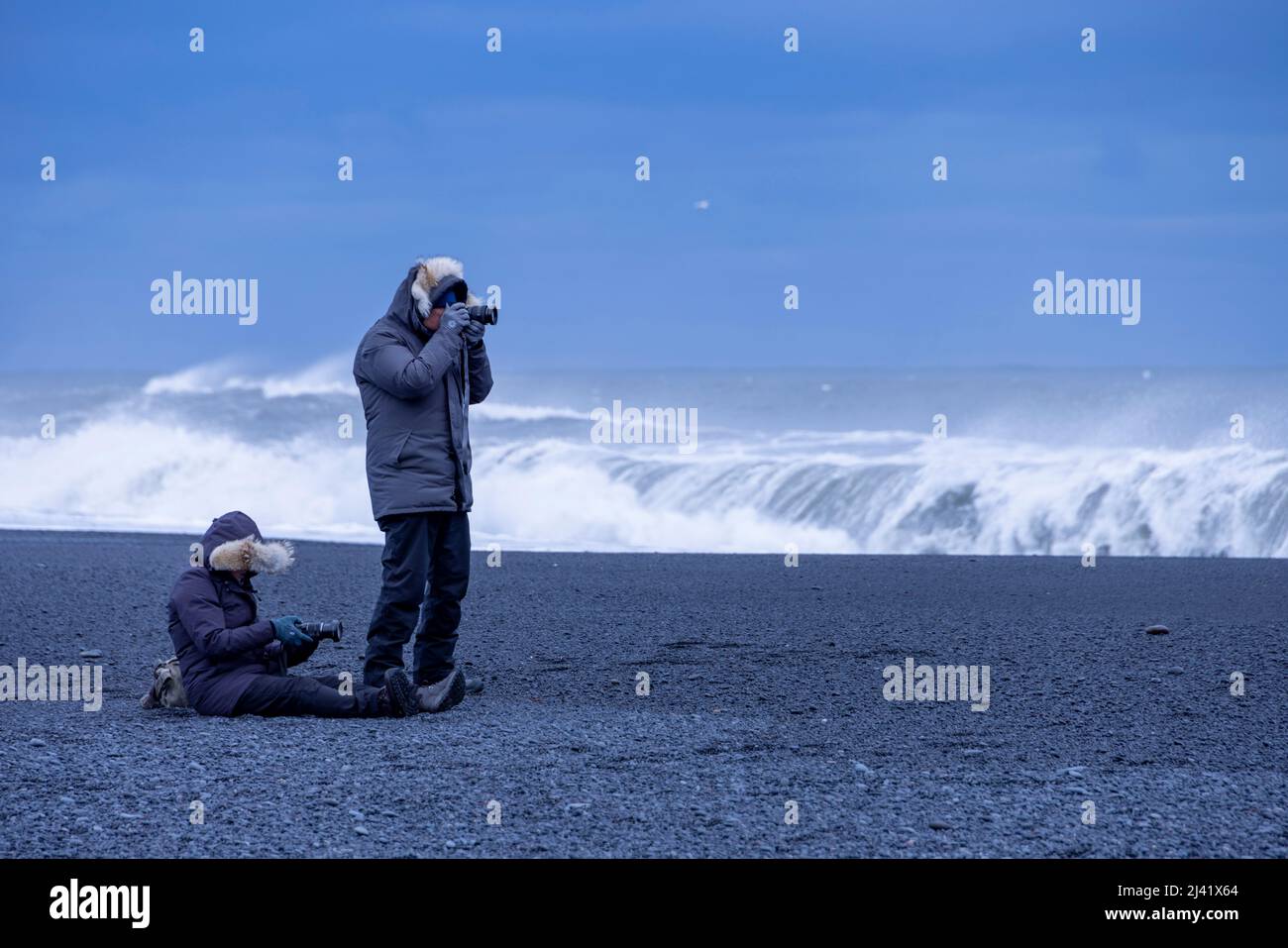 Fotografen am schwarzen Sandstrand Reynisfjara, in der Nähe des Dorfes Vík i Myrdal, im Südosten Islands Stockfoto