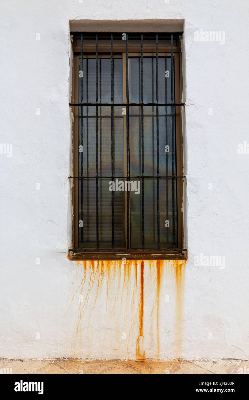 Fenster mit altem Rost, der an der weißen Wand tropfte Stockfoto