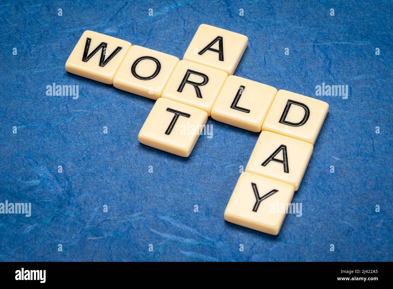 World Art Day - Kreuzworträtsel in Elfenbein Buchstaben Fliesen gegen strukturierte handgemachte Papier Stockfoto