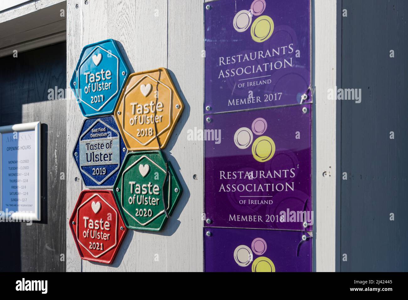 Taste of Ulster Awards von 2017 bis 2021 sowie Plaketten, die die Mitgliedschaft in der Restaurant Association of Ireland außerhalb eines Restaurants zeigen Stockfoto