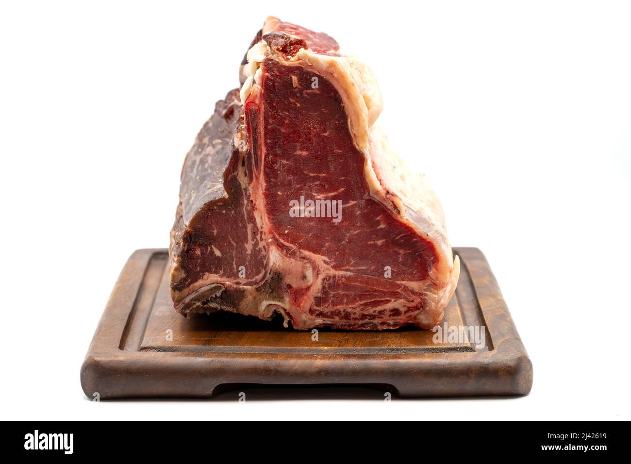 Trocken gereiftes Roh-T-Bone- oder Porterhouse-Rindfleisch-Steak mit Tomaten und Paprika. Weißer Hintergrund. Yakın çekim Stockfoto