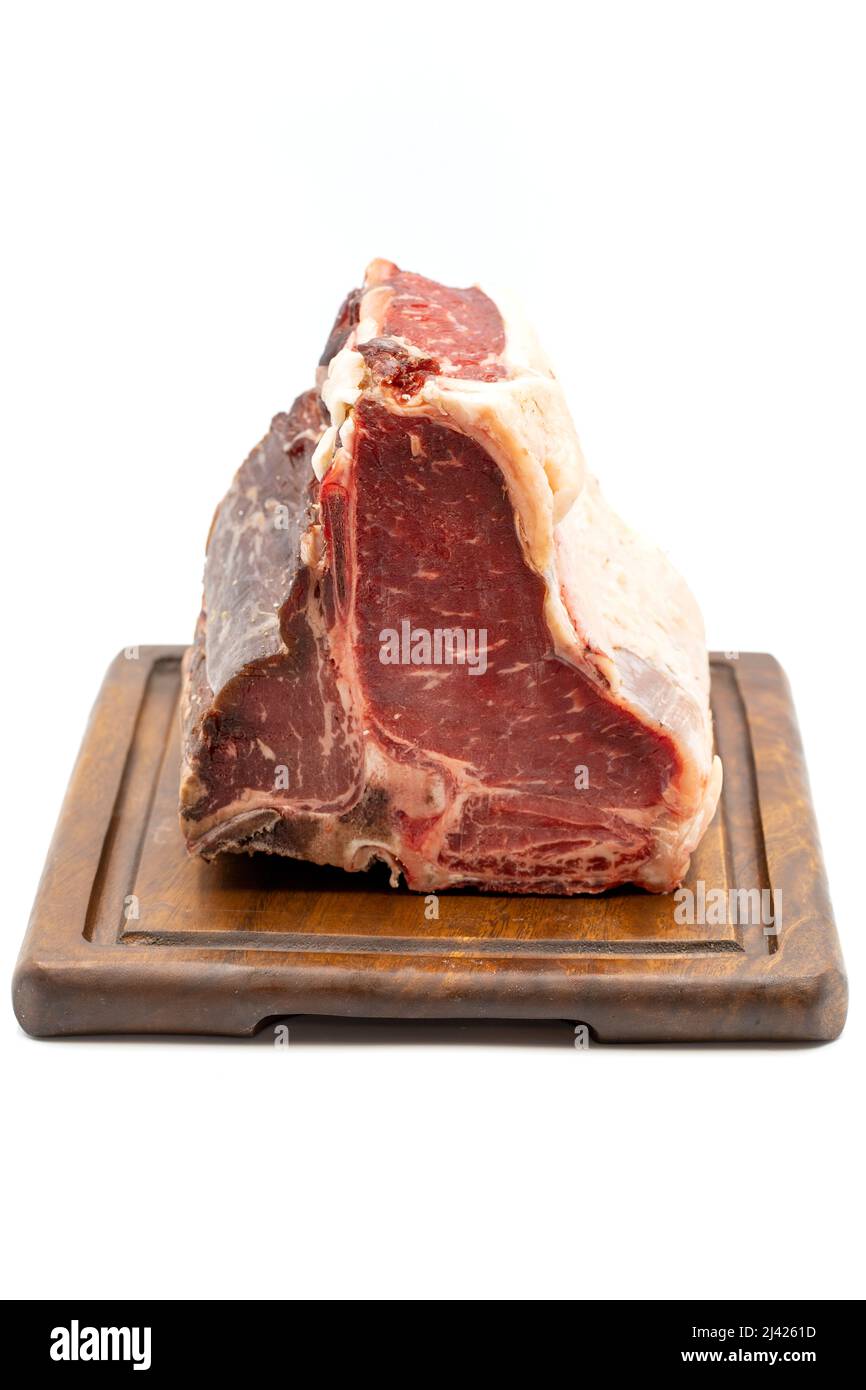 Trocken gereiftes Roh-T-Bone- oder Porterhouse-Rindfleisch-Steak mit Tomaten und Paprika. Weißer Hintergrund. Yakın çekim Stockfoto