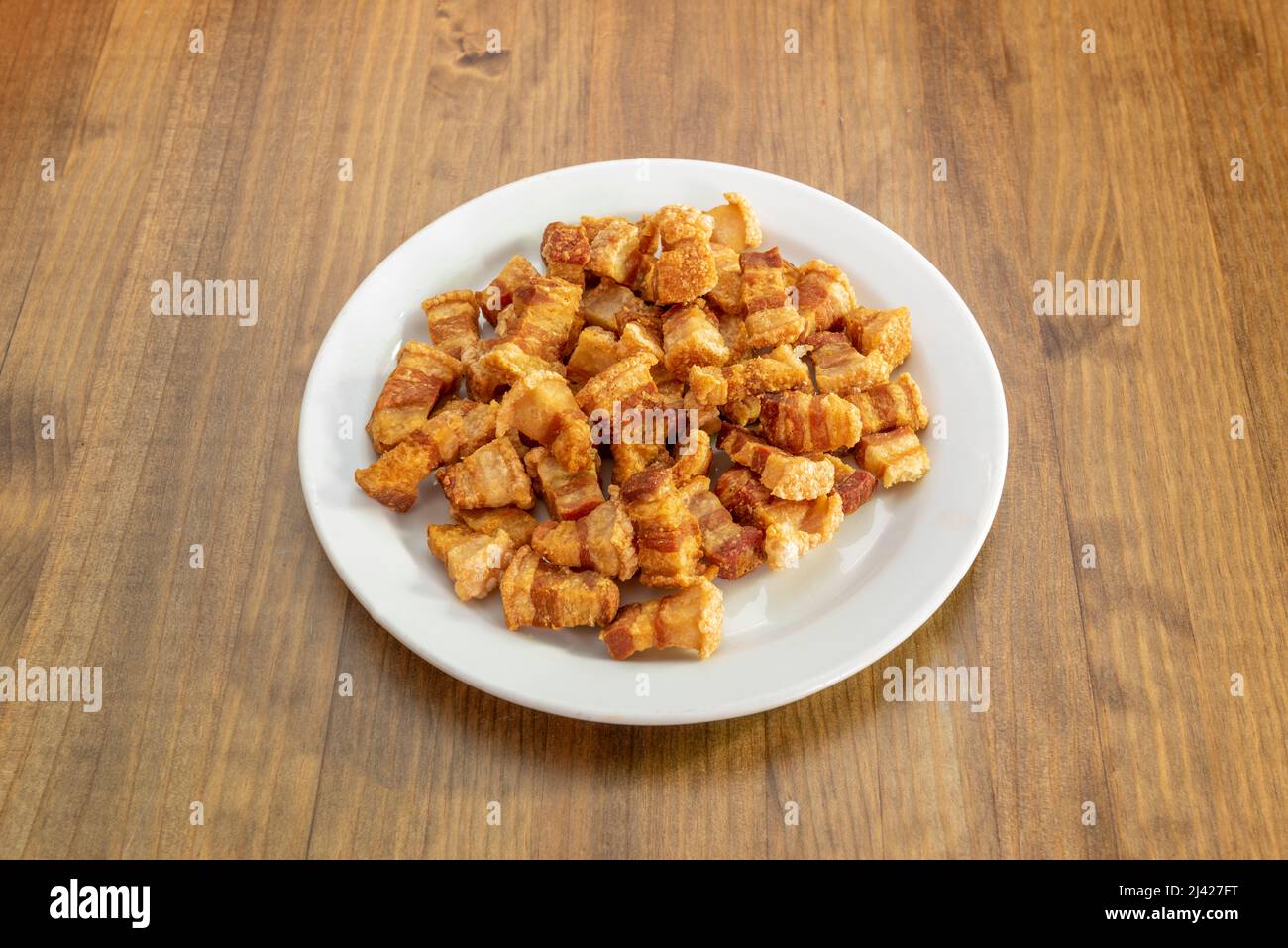 Typisch spanische Tapa von torreznos de soria in Olivenöl auf Holztisch gebraten Stockfoto