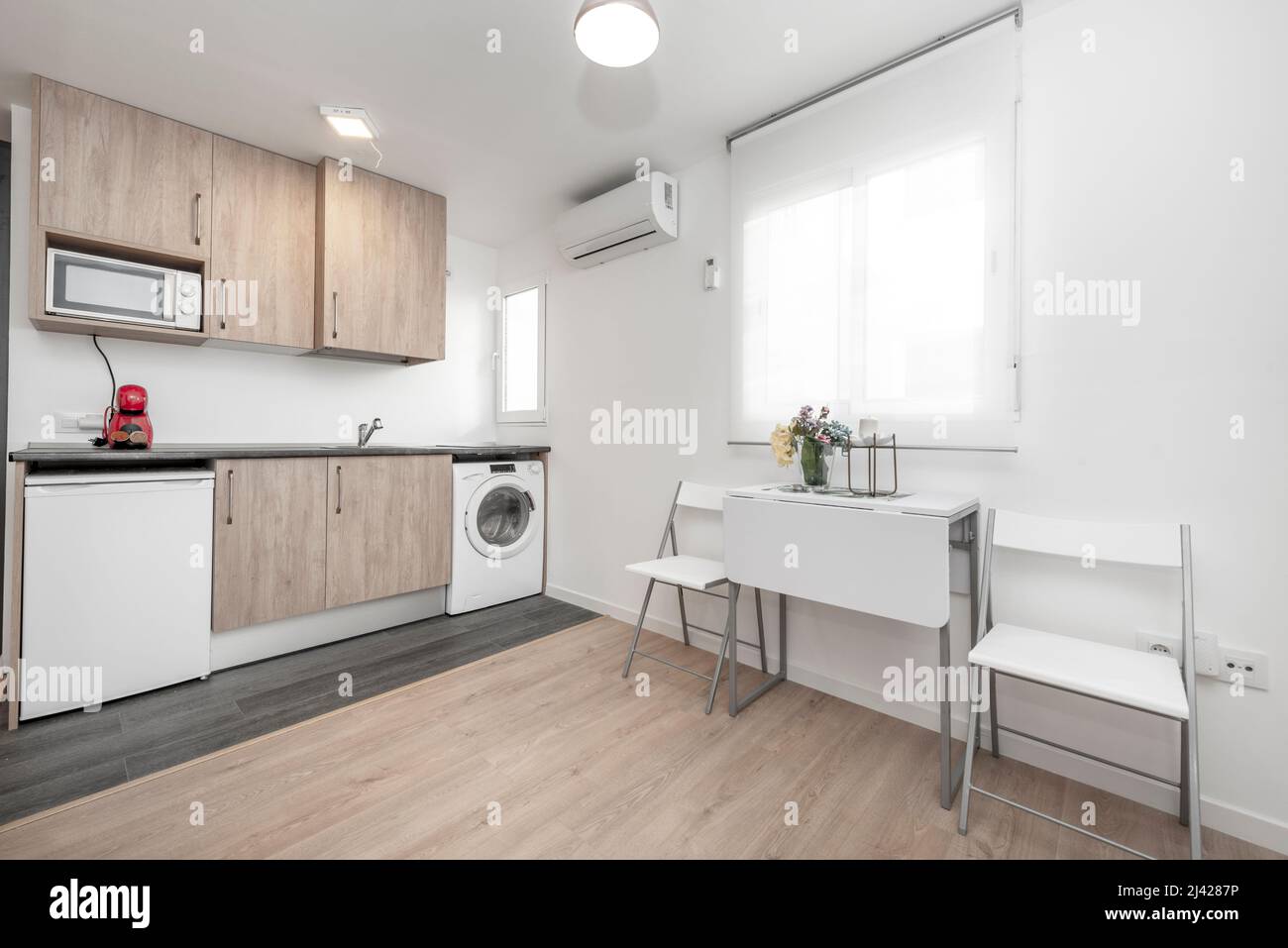 Wohnzimmer und Küche in möbliertem Studio-Apartment für kurzfristige Vermietung Stockfoto