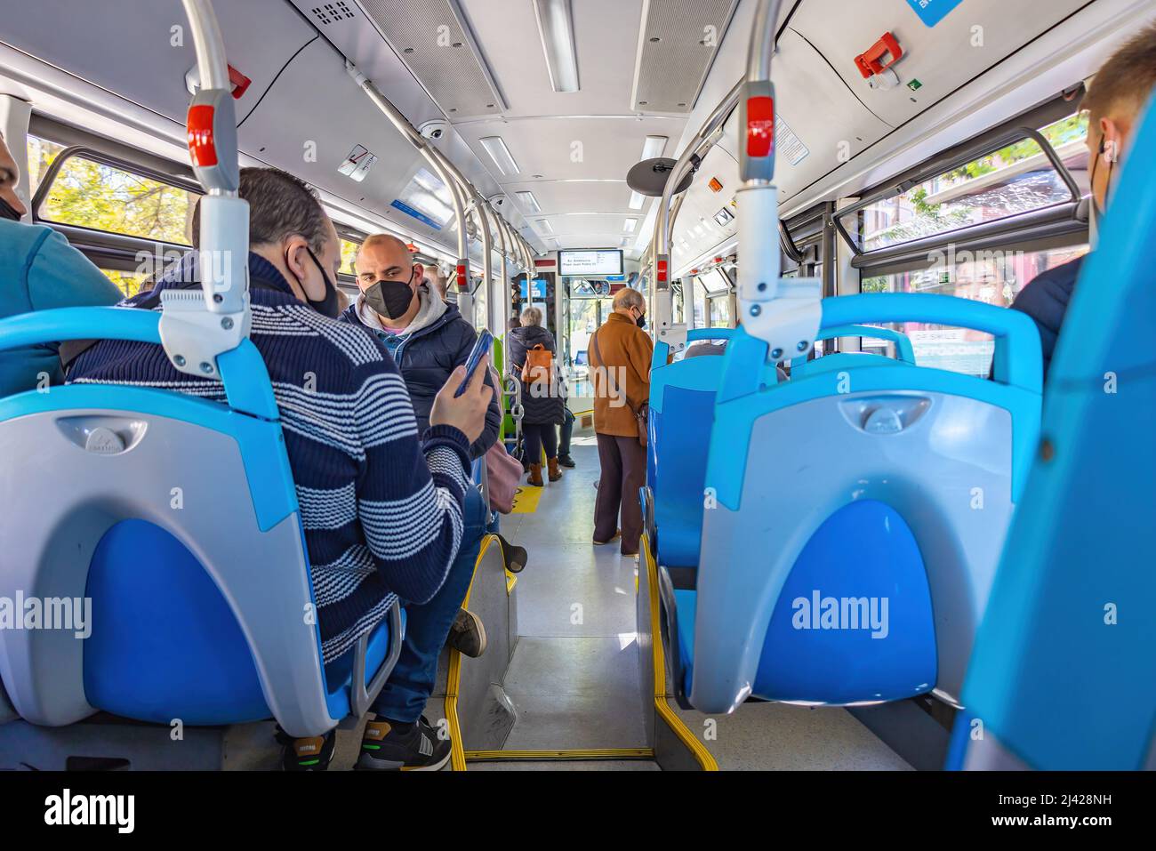 Huelva, Spanien - 9. April 2022: Menschenmassen in einem Bus. Innenansicht eines Stadtbusses mit Fahrgästen mit Schutzmaske und verschiedenen p Stockfoto