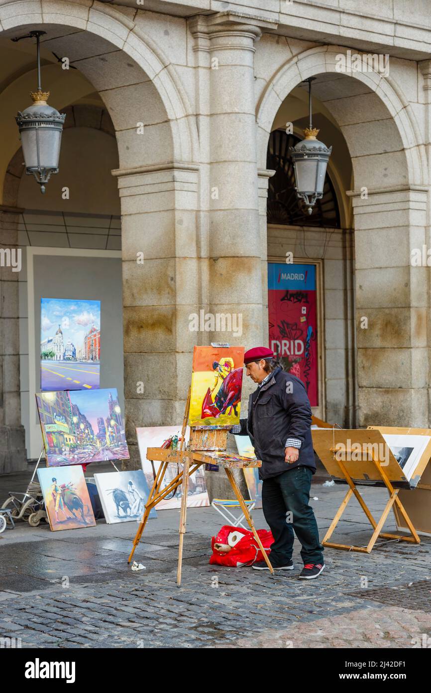 Ein lokaler Straßenkünstler malt farbenfrohe Stierkampfmatador-Szenen für touristische Souvenirs im Zentrum von Madrid, der Hauptstadt Spaniens Stockfoto