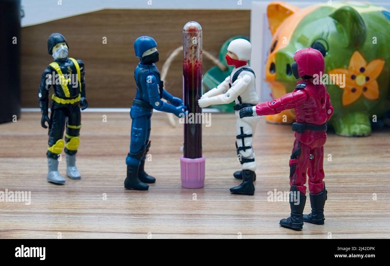 Vier GI Joe Cobra-Figuren, die eine Blutprobe auf einem Schreibtisch bewegen Stockfoto