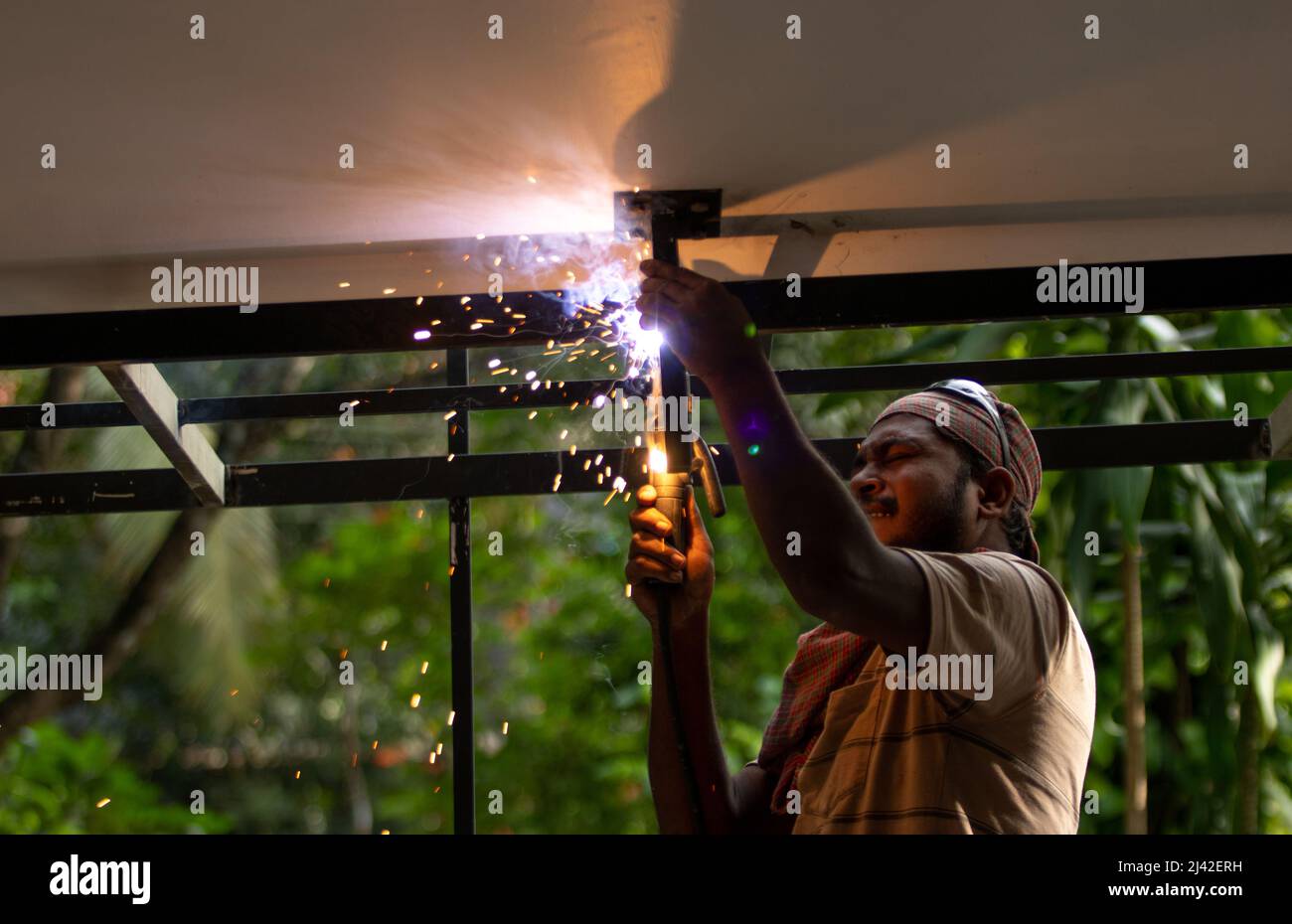 Ein Mann, der Schweißarbeiten auf dem Dach macht Stockfoto