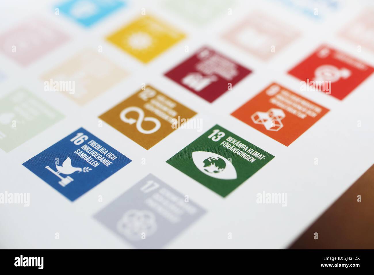 Atlas Copco Jahresbericht. Symbole in verschiedenen Farben über die globalen Ziele für nachhaltige Entwicklung. Hier ist ein grünes Symbol für den Kampf gegen den Klimawandel. Stockfoto