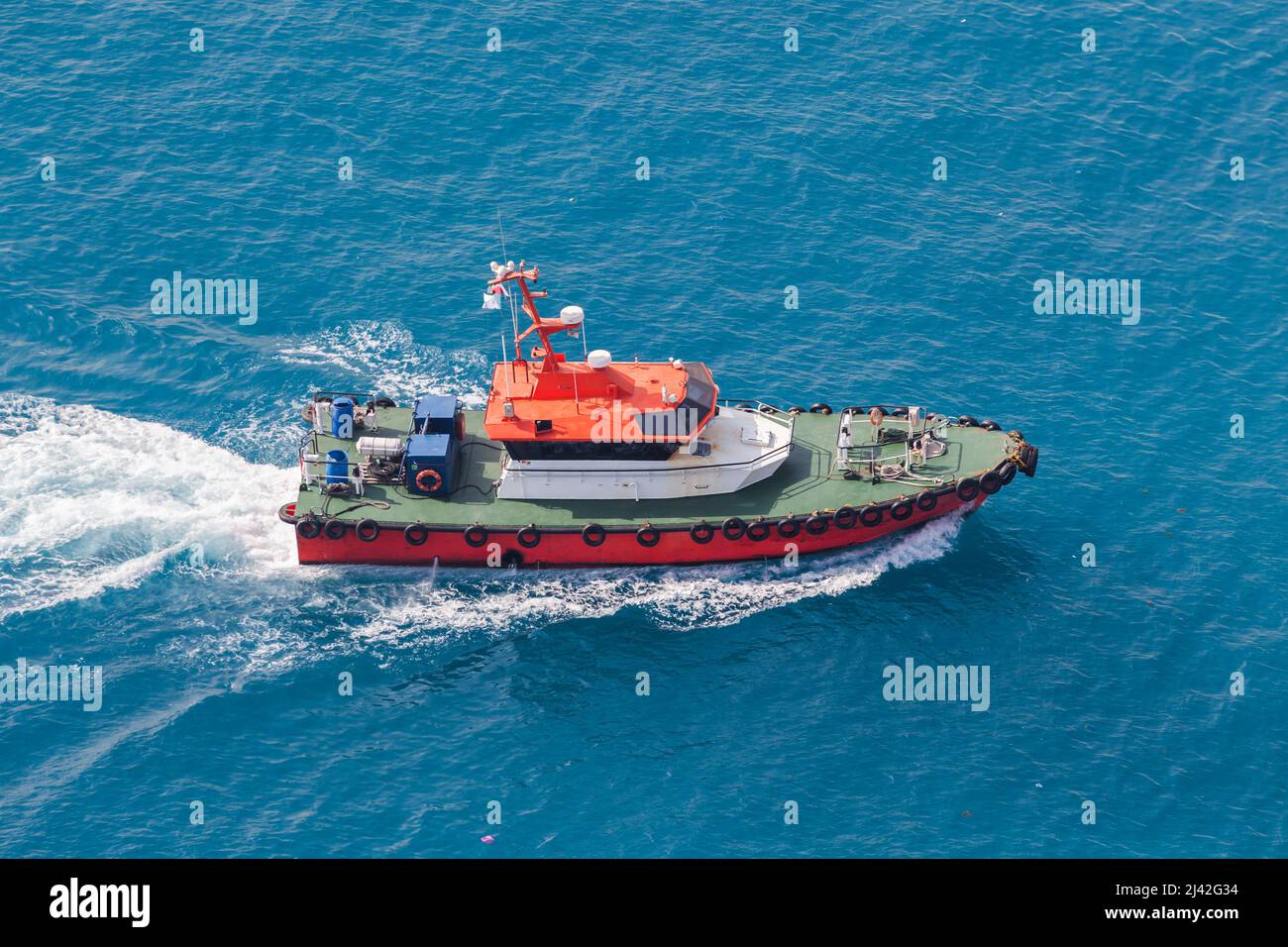 Pilotboot mit rotem Rumpf und grünem Deck ist unterwegs. Rotes Meer, Hafen von Jeddah, Saudi-Arabien Stockfoto