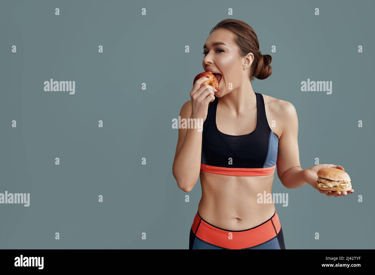 Porträt einer fröhlichen jungen Frau, die Apfel isst.Diät. Diät, Gesunde Ernährung Stockfoto