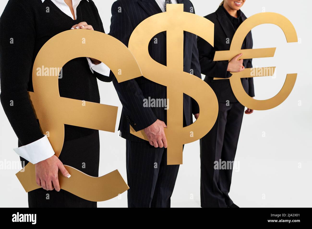 Anonymes Business People Team, Geschäftsmann und Geschäftsfrauen, die große Goldgeld-Währungssymbole, Britisches Pfund, Dollar und Euro halten. Tauschen Sie die Ratte aus Stockfoto