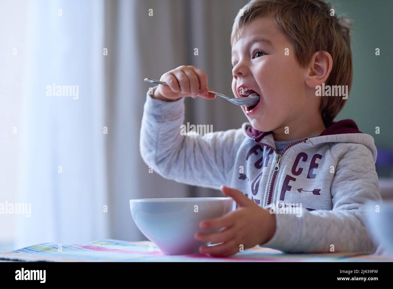 Nichts ist besser als ein leckeres Frühstück. Ein kleiner Junge, der zu Hause frühstücken kann. Stockfoto