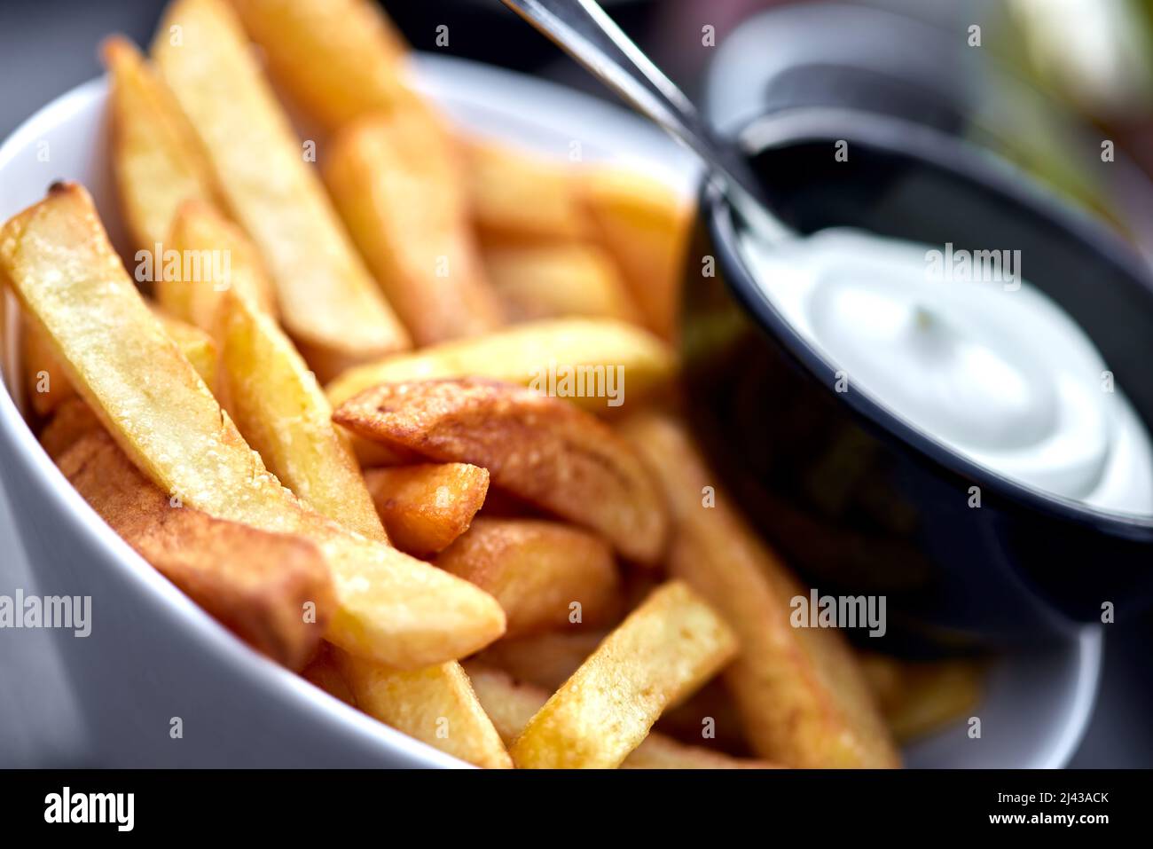 Pommes Frites mit Mayonnaise in einer weißen Schüssel – Nahaufnahme Stockfoto