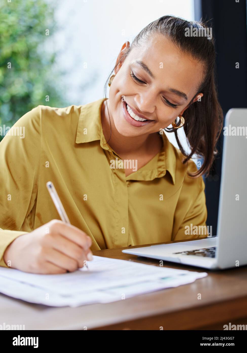 Dieser Papierkram wird sich nicht selbst vervollständigen. Eine kleine Aufnahme einer attraktiven jungen Geschäftsfrau, die während der Arbeit von zu Hause aus Schreibarbeiten ausfüllt. Stockfoto