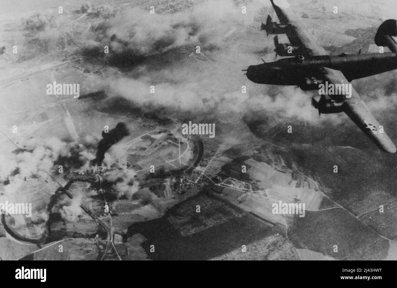 Der Befreier schwingt vom Flugplatz St. Dizier ab -- nach dem Entladen seiner tödlichen Ladung auf die Gebäude am Ende des Feldes. Eine aufragender Pfeiler aus schwarzem Rauch markiert das Grab eines anderen Nazi-Flugplatzes. Die B-24 Liberator ist nach ihrer Arbeit steil abgelegen und macht sich auf den Weg nach Hause. Bei diesem Angriff am 24.. März waren die schweren Bomber praktisch nicht entgegengesetzt, und die Bombardierungen erzielten gute Ergebnisse. 14. April 1944. (Foto von einem offiziellen Foto der Vereinigten Staaten). Stockfoto