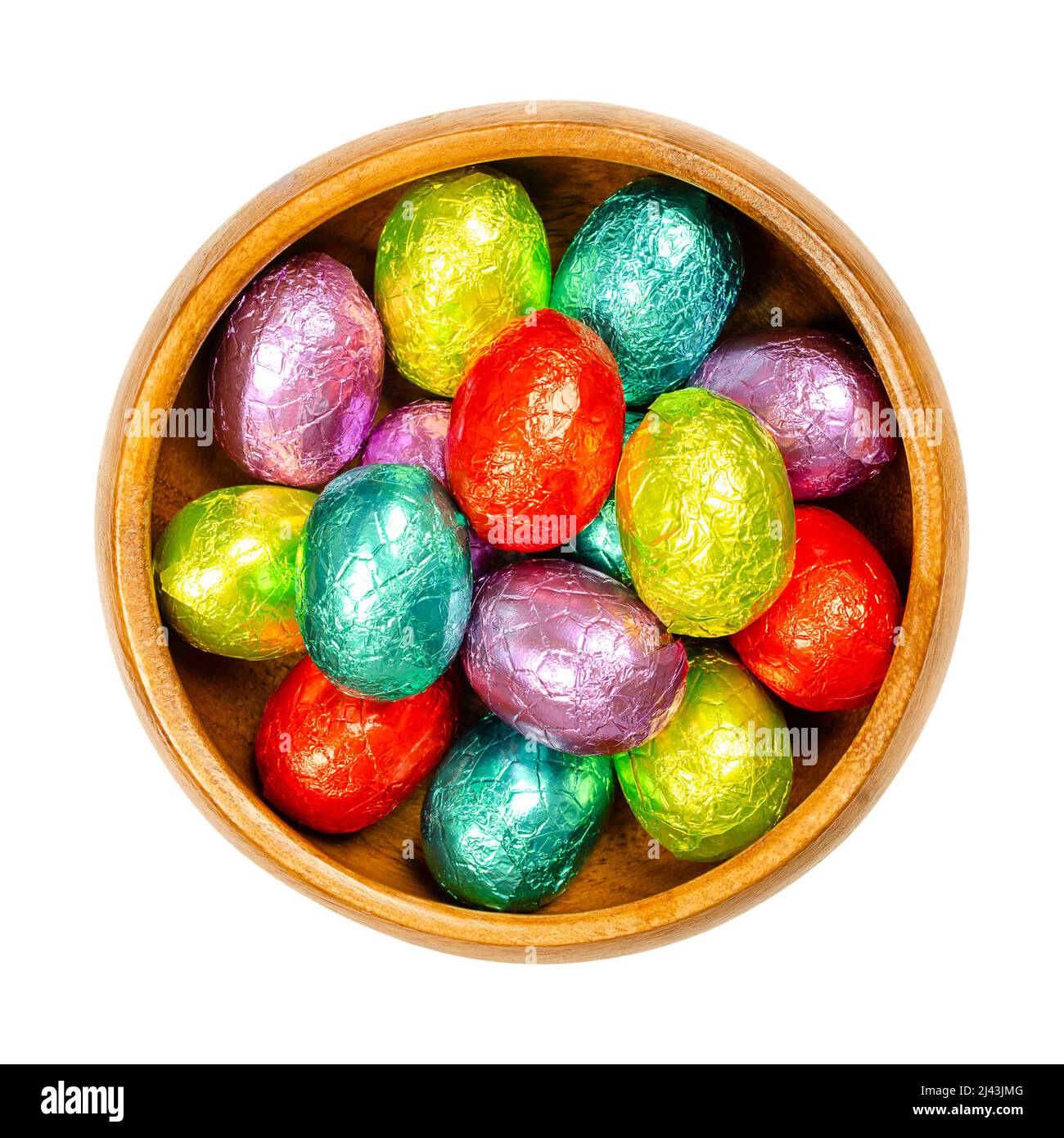 Gemischte farbige, in Folie gewickelte Schokoladen-Ostereier in einer Holzschale. Mini-Schokolade Eier, süße Süßigkeiten, in Aluminiumfolie in verschiedenen Farben gewickelt. Stockfoto