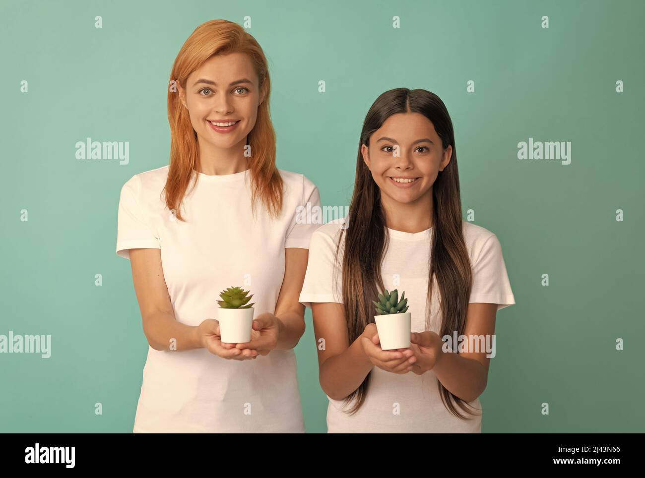 Glückliche Adoptivfamilie von adoptierten Tochter Kind und Frau Mutter lächeln halten Zimmerpflanzen, Adoption Stockfoto