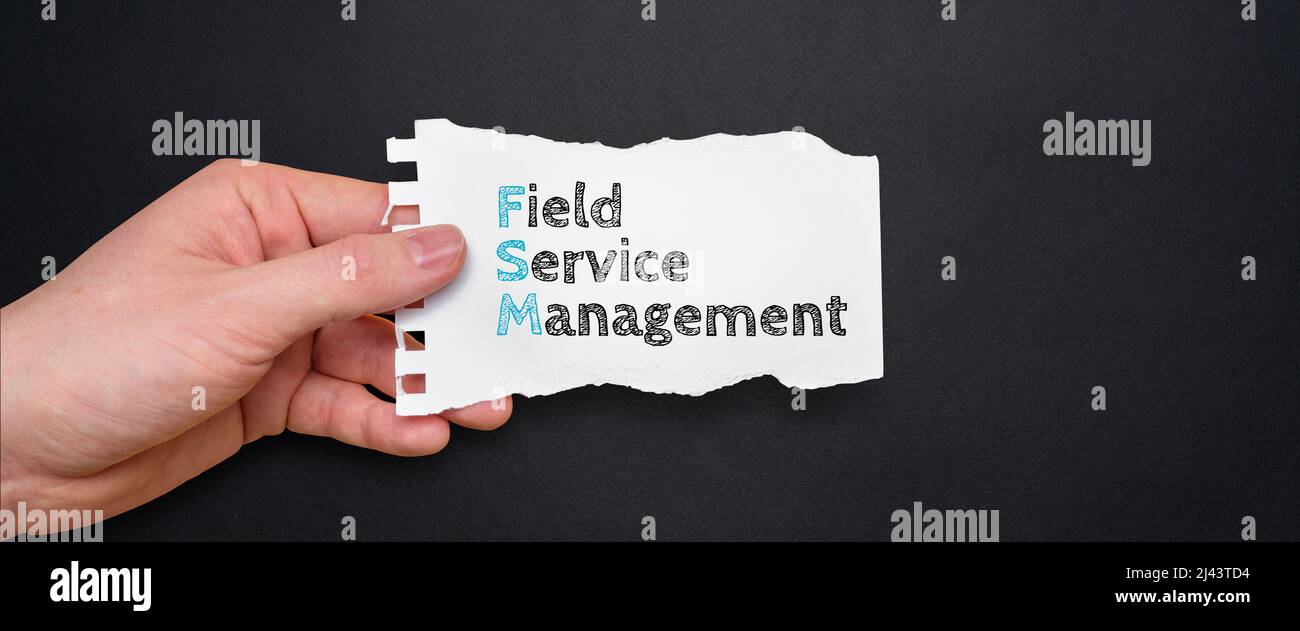 Akronym FSM oder Field Service Management. Person, die ein Stück Papier mit Text hält. Stockfoto