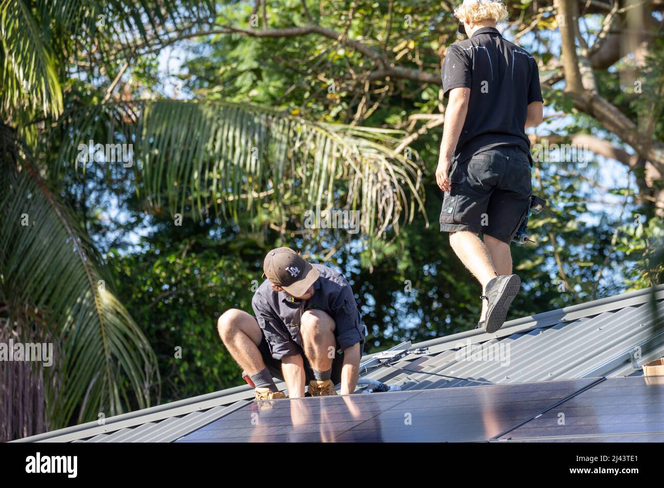 Installateure von Solaranlagen montieren schwarze Alpha-Solarmodule von REC auf dem Dach eines Wohnhauses in Sydney, NSW, Australien Stockfoto