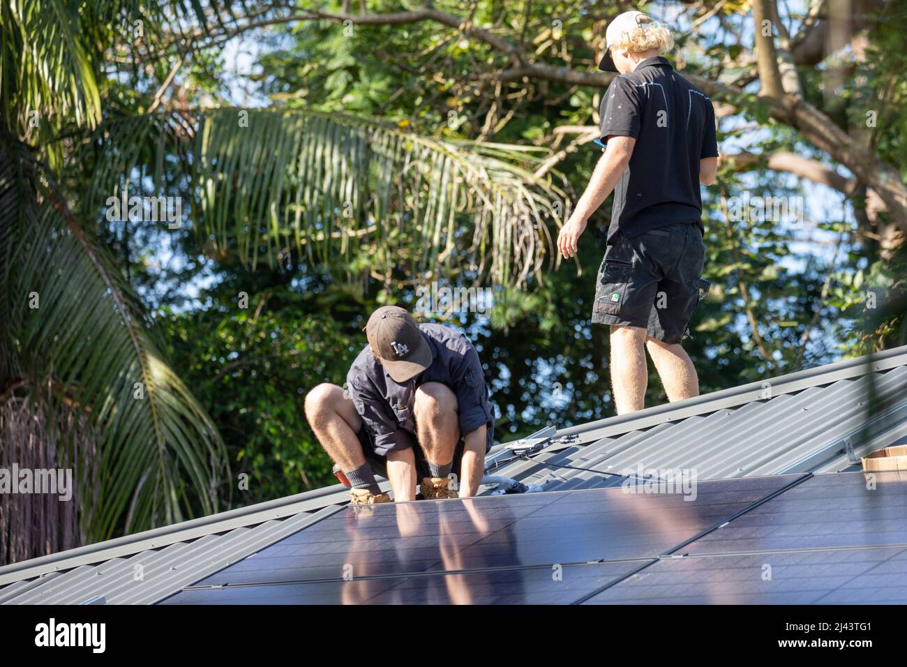 Installateure von Solaranlagen montieren schwarze Alpha-Solarmodule von REC auf dem Dach eines Wohnhauses in Sydney, NSW, Australien Stockfoto