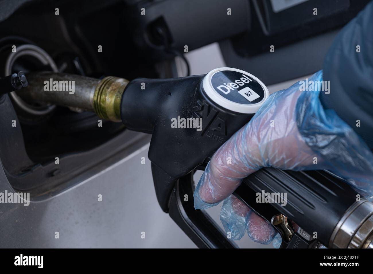 Diesel. Tanken des Autos.Betanken der Pistole in den Händen eines Mannes in einem Handschuh.Ein Mann füllt einen Autotank auf. Kraftstoffpreis in Europa. Stockfoto