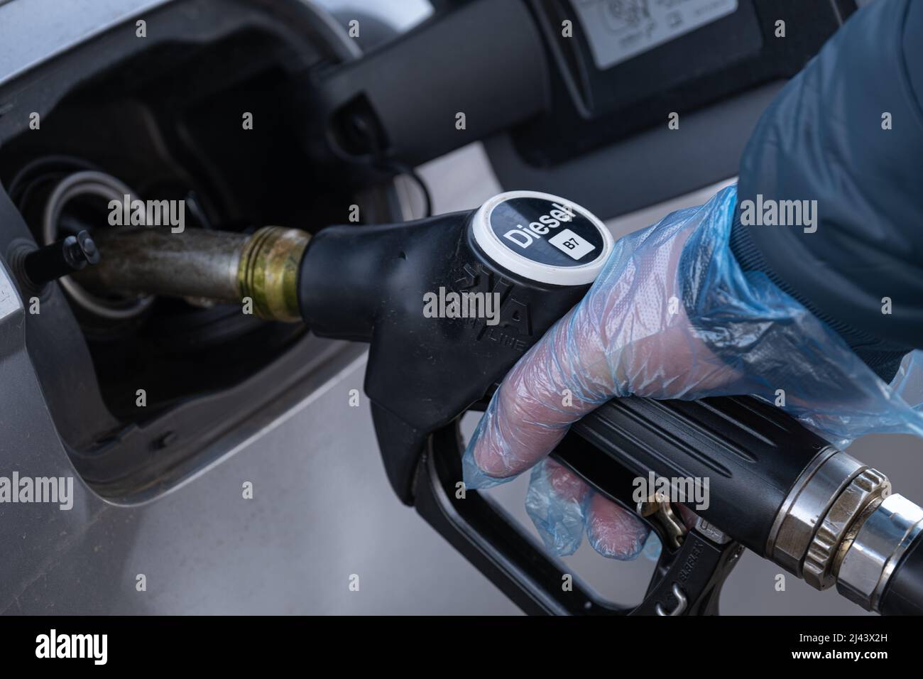 Diesel. Tanken des Autos.Füllen der Pistole in den Händen eines Mannes in einem Handschuh.Ein Mann füllt einen Tank mit Dieselkraftstoff. Kraftstoffpreis in Europa. Stockfoto