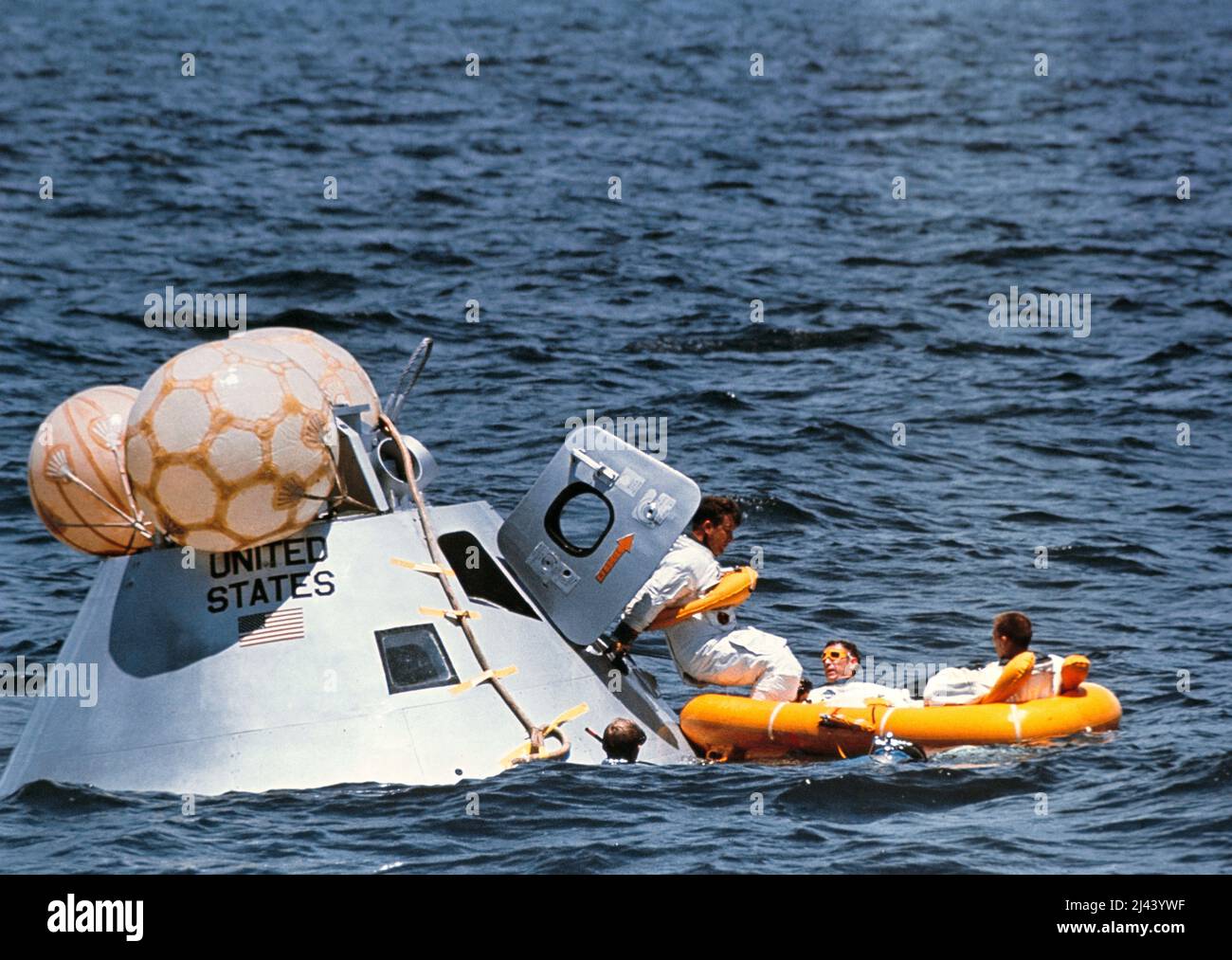 Die Hauptmannschaft der ersten bemannten Apollo-Mission, die am Wasseraustraining im Golf von Mexiko teilnahm. Von links nach rechts befinden sich die Astronauten Walter Schirra (der ins Rettungsinsel tritt), Donn Eisele und Walter Cunningham. Stockfoto