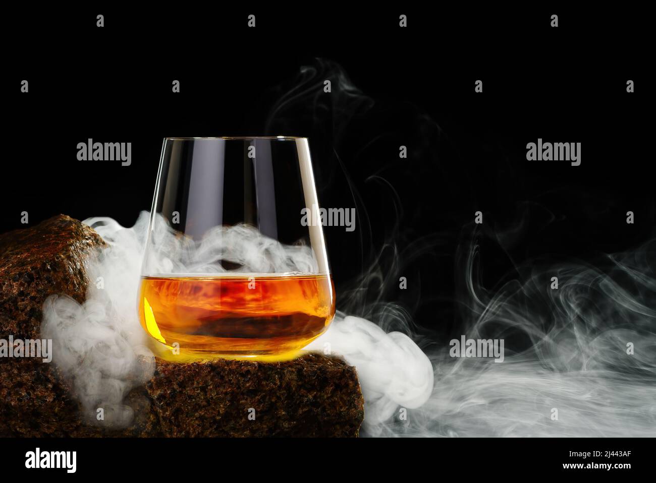 Wisky Glas auf dem Felsen auf schwarzem Hintergrund. Wisky Glas ohne Eis Stockfoto