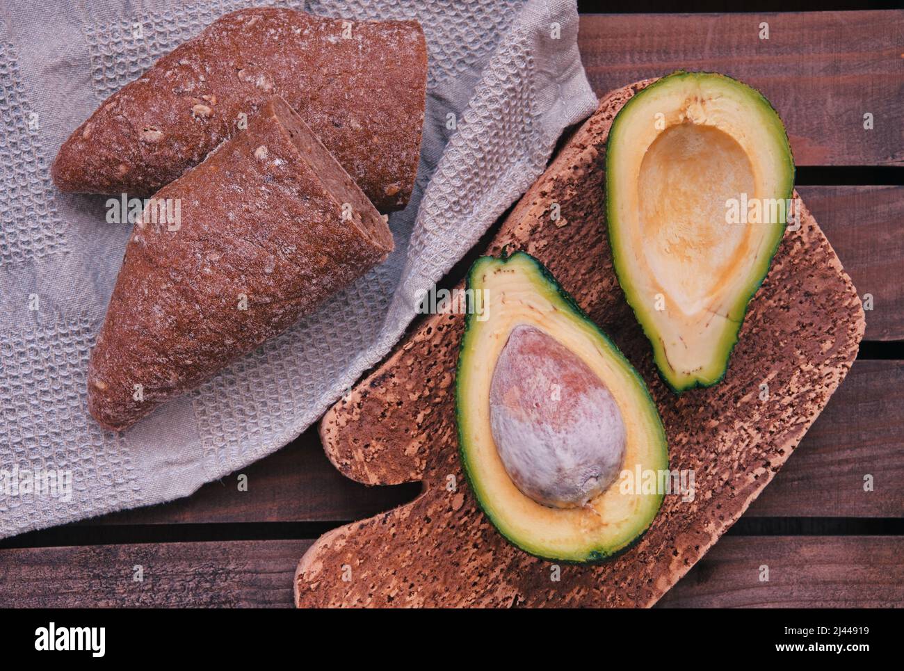 Oben Aufnahme von Avocado und Brot vor Holzhintergrund Stockfoto