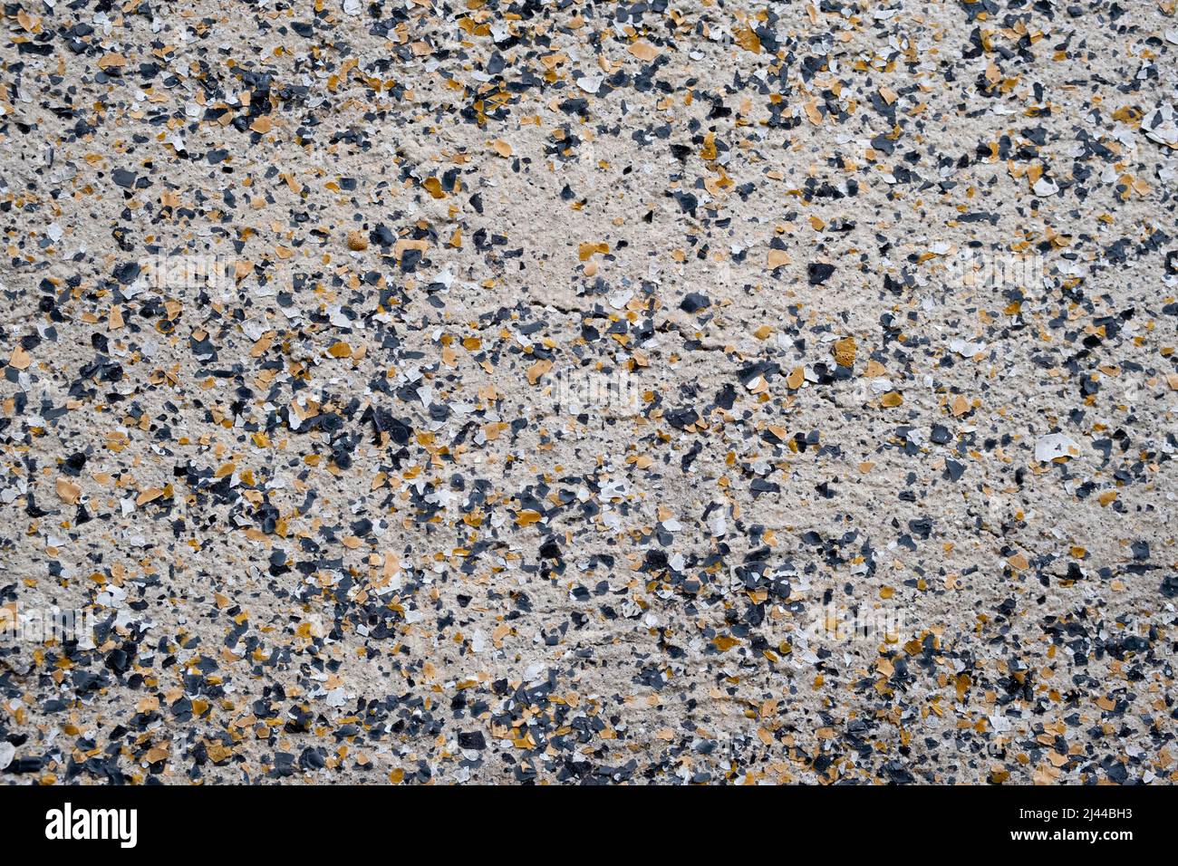 Nahaufnahme von cremefarbenen, braunen und schwarzen Granitflecken an der alten Wand in Indonesien Stockfoto