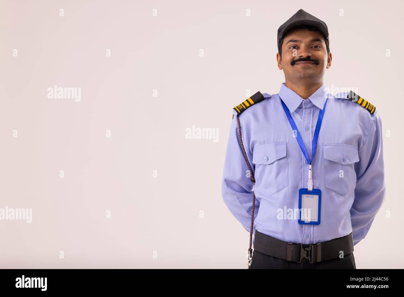 Porträt des Sicherheitsbeamten, der mit den Händen hinter dem Rücken posiert Stockfoto