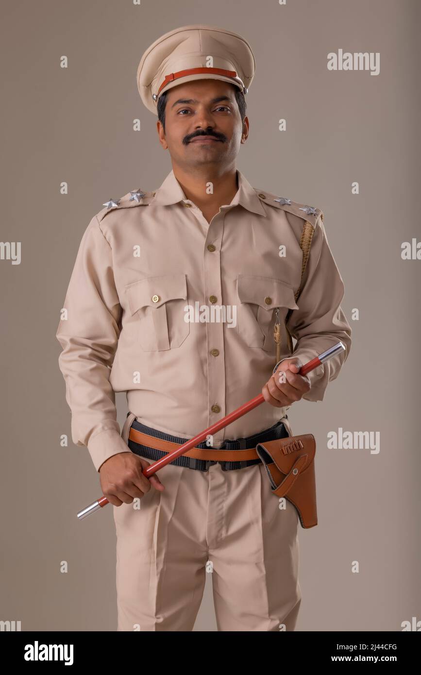 Porträt eines indischen Polizisten, der mit einem Stab in der Hand stand Stockfoto