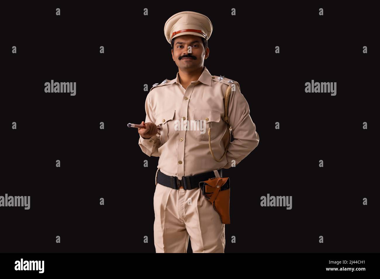 Porträt eines indischen Polizisten, der mit Stab und Hand hinter dem Rücken steht Stockfoto