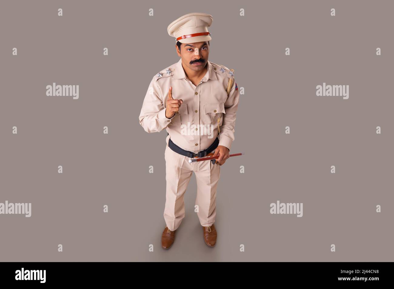 Draufsicht auf einen indischen Polizisten, der mit dem Zeigefinger warnt Stockfoto