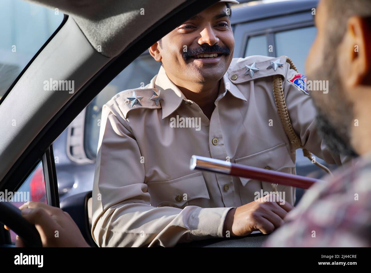 Porträt eines indischen Polizisten im Gespräch mit dem Autofahrer Stockfoto