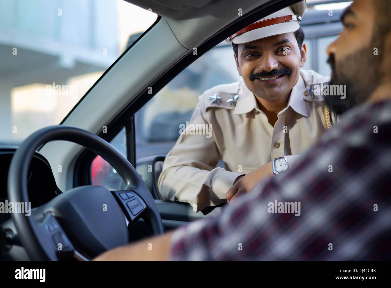 Porträt eines indischen Polizisten im Gespräch mit dem Autofahrer Stockfoto