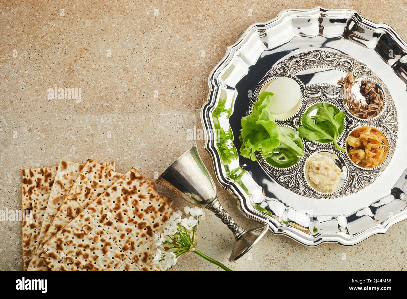 Passah Seder Teller mit traditionellem Essen auf Travertin Stein Hintergrund Stockfoto