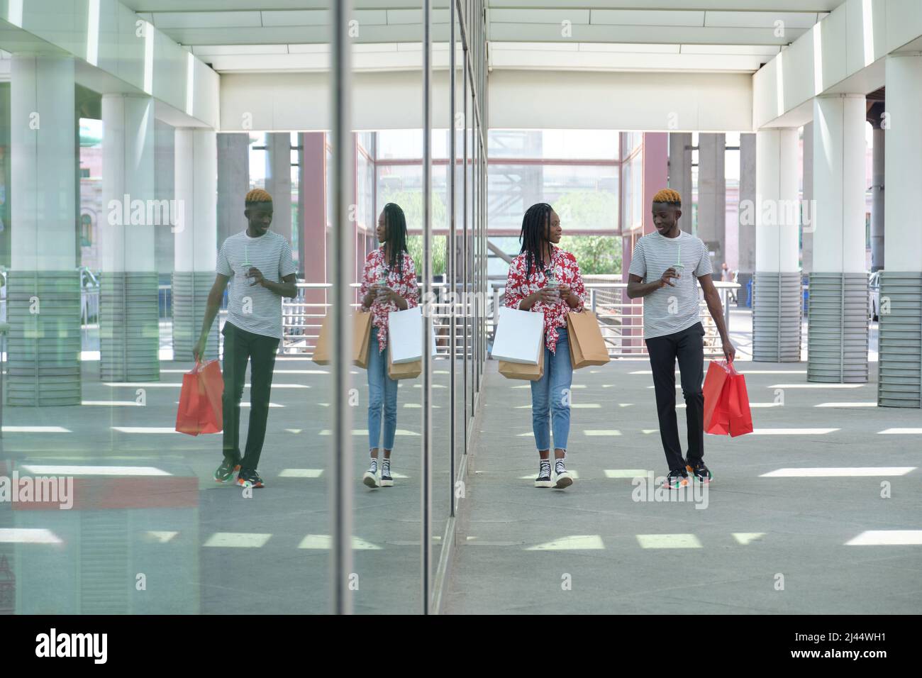 Junges schwarzes Paar, das erfrischende Getränke trinkt und einkaufen geht. Stockfoto