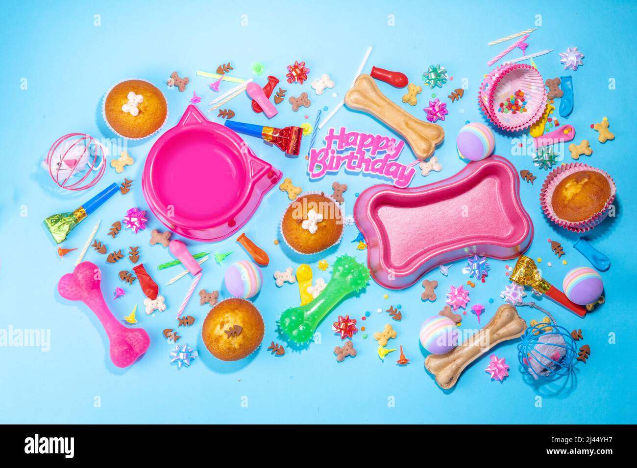 PET Happy Birthday Hintergrund mit Set Hund und Katze Snack, Futter und Spielzeug, Knochen und Katze geformte Schale, Geburtstag Cupcakes mit Happy Birthday Kerzen und ein Stockfoto