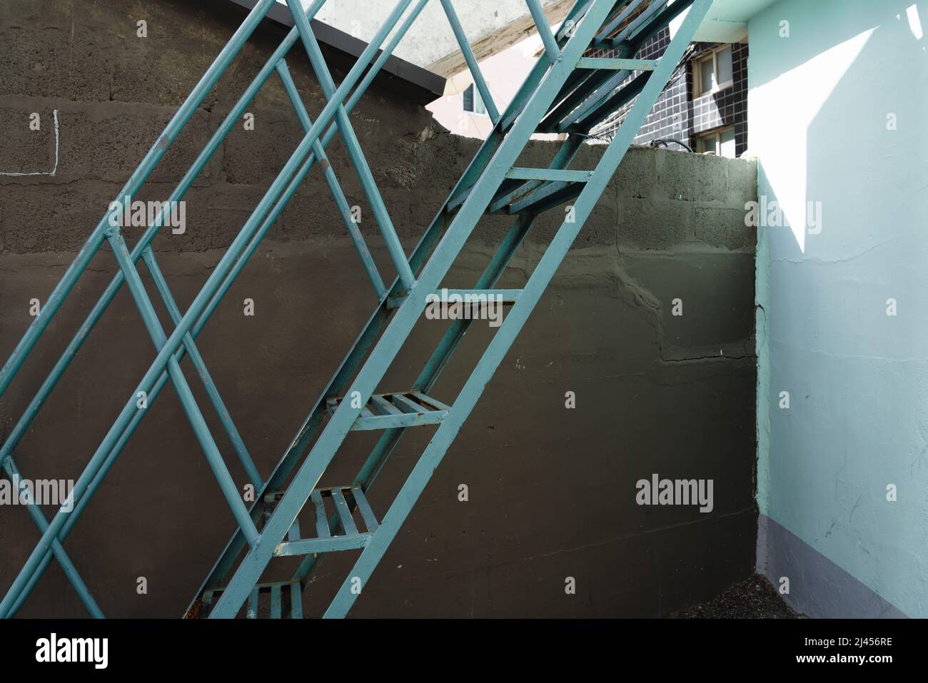 Blaue Metalltreppe mit grauer Wand Stockfoto