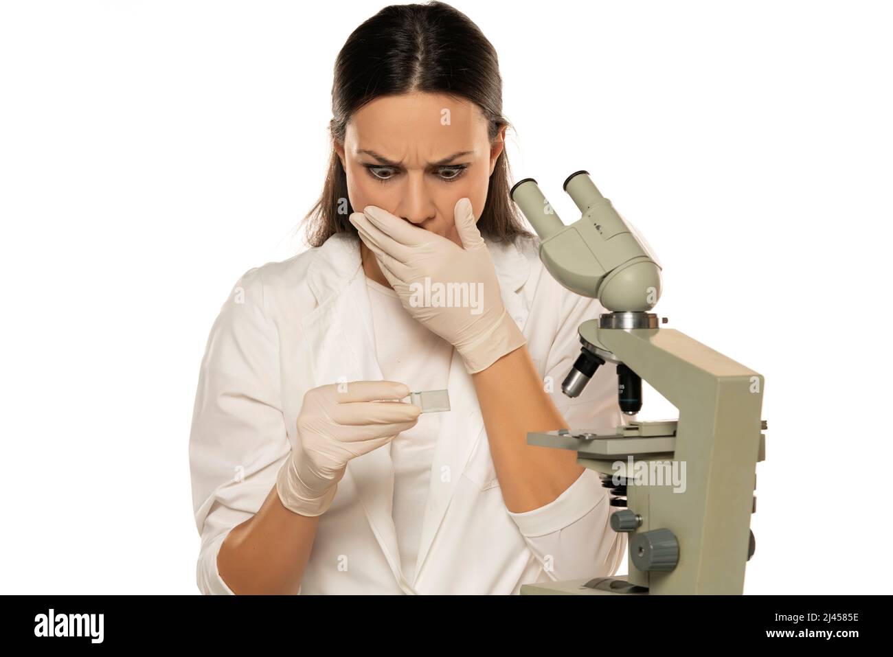 Porträt einer schockierten Wissenschaftlerin mit Mikroskop auf weißem Hintergrund Stockfoto